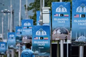 A police personnel walks past posters highlighting Pakistan's mediation of Iran-US peace talks, at the Red Zone area in Islamabad on April 18, 2026. No date has been set for the next round of Iran-US peace talks. (AFP)