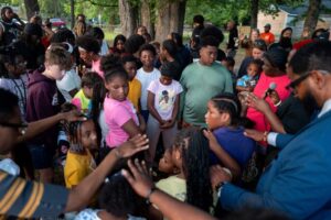 SHREVEPORT, LOUISIANA - APRIL 20: Children huddle to pray during a memorial gathering on April 20, 2026 in Shreveport, Louisiana. Eight children were killed and two women were wounded during a domestic violence incident in the early morning hours of April 19th, according to local authorities. (Photo by Brandon Bell/Getty Images)