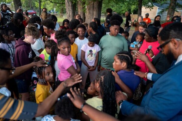 SHREVEPORT, LOUISIANA - APRIL 20: Children huddle to pray during a memorial gathering on April 20, 2026 in Shreveport, Louisiana. Eight children were killed and two women were wounded during a domestic violence incident in the early morning hours of April 19th, according to local authorities. (Photo by Brandon Bell/Getty Images)