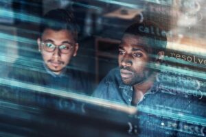 Two people look at blurred lines of code.