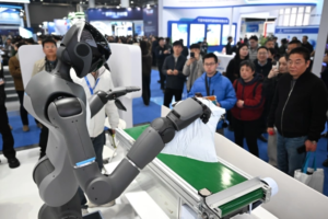 People watch a humanoid robot performs a task at a exhibition in China in March 2026. Photo from X