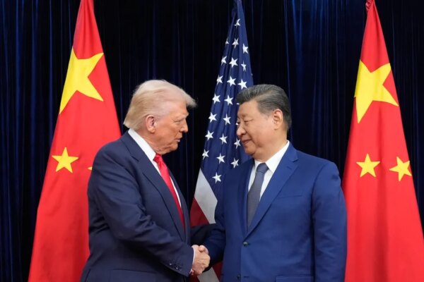 Donald Trump and Xi Jinping shaking hands, with the US and Chinese flags behind them.