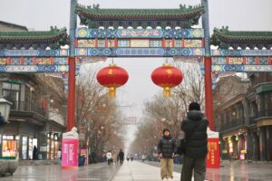 Tourists take photographs at Qianmen Pedestrian Street in Beijing.