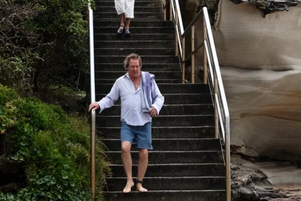 Men walking down steps toward a beach.