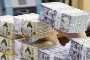 An employee arranges U.S. dollar bills and 50,000 won notes at a branch of Hana Bank in central Seoul, April 3. Yonhap