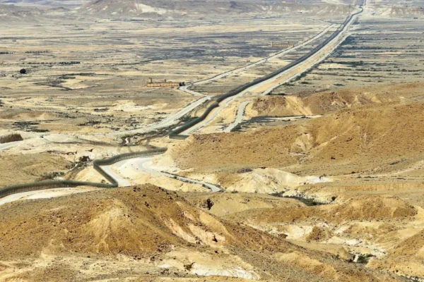 THE BORDER fence cuts across the arid landscape. Looking north, Egypt and the Sinai Desert are to the left of the fence and Israel and the Negev Desert lie on its right.