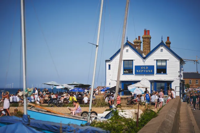 A crowded beach with a local pub during the Summer Bank Holiday.