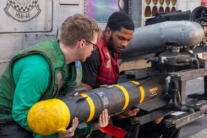 U.S. sailors, assigned to Helicopter Maritime Strike Squadron 46, unload an AGM-114 Hellfire missile from an MH-60R Sea Hawk helicopter during the Iran war at an undisclosed location, March 23, 2026. (via REUTERS)