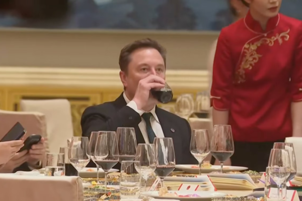 Musk taking a swig of a red drink