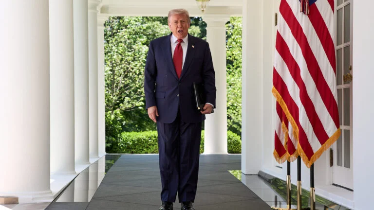 President Donald Trump walks through the Colonnade of the White House.