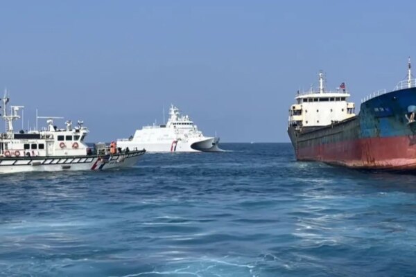 Two Taiwan Coast Guard personnel boarding a Togo-flagged cargo ship in waters off Penghu, Taiwan