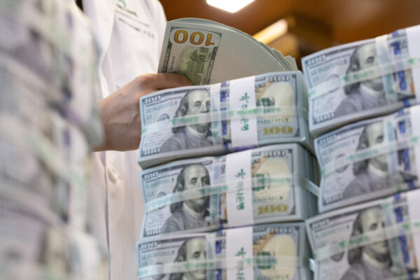 A staff member holds dollar bills at Hana Bank’s anti-counterfeiting center in Jung-gu, Seoul. (Yoon Chang-bin/The Korea Herald)