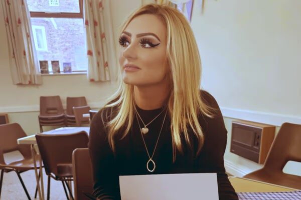 Megan Innocent sits at a table signing one of her books