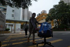 A care team member (front) helps a resident move her belongings from Wang Chi House of Wang Fuk Court on May 15. The building was the only block left largely unscathed in last year’s deadly Tai Po fire. Photo: Sun Yeung