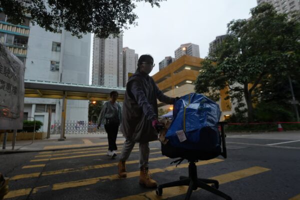 A care team member (front) helps a resident move her belongings from Wang Chi House of Wang Fuk Court on May 15. The building was the only block left largely unscathed in last year’s deadly Tai Po fire. Photo: Sun Yeung