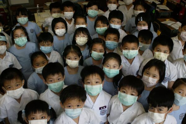 S.K.H. St. Peter’s Primary School students in Shek Tong Tsui prepare to take off their face masks after the World Health Organization announced the removal of Hong Kong from a list of Sars-affected areas. June 23, 2003. Photo: Oliver Tsang