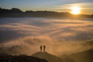 TOPSHOT - Hindu devotees of the Tengger community are seen through low-lying clouds at sunrise as they ascend the active Mount Bromo volcano to present offerings of rice, fruit, livestock and other items as part of the Yadnya Kasada festival near Probolinggo, East Java province on June 1, 2026. The Yadnya Kasada ceremony is a ritual of the Tenggerese people, a sub-ethnic group of Javanese in eastern Java, in which offerings are thrown into the crater of Mount Bromo as a form of gratitude, prayer for safety, and fulfillment of a legendary vow to the mountain's deity. (Photo by JUNI KRISWANTO / AFP via Getty Images)