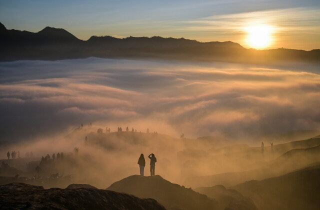 TOPSHOT - Hindu devotees of the Tengger community are seen through low-lying clouds at sunrise as they ascend the active Mount Bromo volcano to present offerings of rice, fruit, livestock and other items as part of the Yadnya Kasada festival near Probolinggo, East Java province on June 1, 2026. The Yadnya Kasada ceremony is a ritual of the Tenggerese people, a sub-ethnic group of Javanese in eastern Java, in which offerings are thrown into the crater of Mount Bromo as a form of gratitude, prayer for safety, and fulfillment of a legendary vow to the mountain's deity. (Photo by JUNI KRISWANTO / AFP via Getty Images)