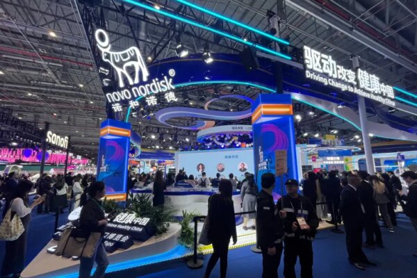 People walk past the Novo Nordisk booth at the 8th China International Import Expo (CIIE) in Shanghai, China November 6, 2025. REUTERS/Andrew Silver