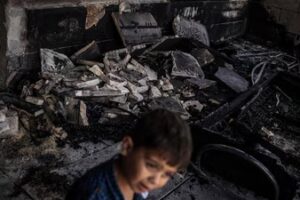 A young Palestinian boy walks in front of a mosque allegedly burned by Israeli settlers in the village of Qusra, south of Nablus in the Israeli-occupied West Bank on July 26, 2026. (AFP)