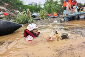 Rescuers remove fences to allow rescue boats to pass through in Gantang Town, Binyang County of Nanning, south China's Guangxi Zhuang Autonomous Region, July 7, 2026.