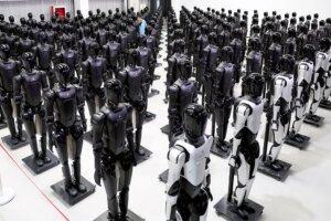 Rows of humanoid robots stand stationary in a room.