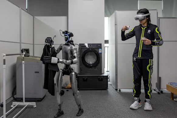 An IO-AI Tech staff member trains a humanoid robot to do laundry at the company’s headquarters in Shenzhen.