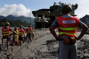 Rescuer help women to move through a muddy road following flash floods and a mudslide in Trishuli,, Nepal, August 28. (REUTERS)