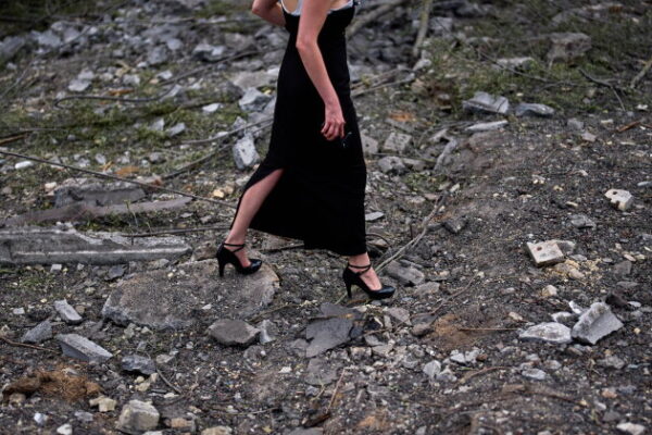 A woman walks across the debris in the aftermath of an overnight Russian missile and drone attack on Kyiv, Ukraine, Thursday, Aug. 20, 2026 (AP Photo/Francisco Seco)