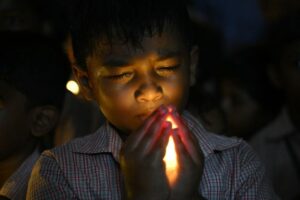 A school student holds a LED candle as he pays homage to people who died in Nepal's flash flood, in Chennai on August 28, 2026.