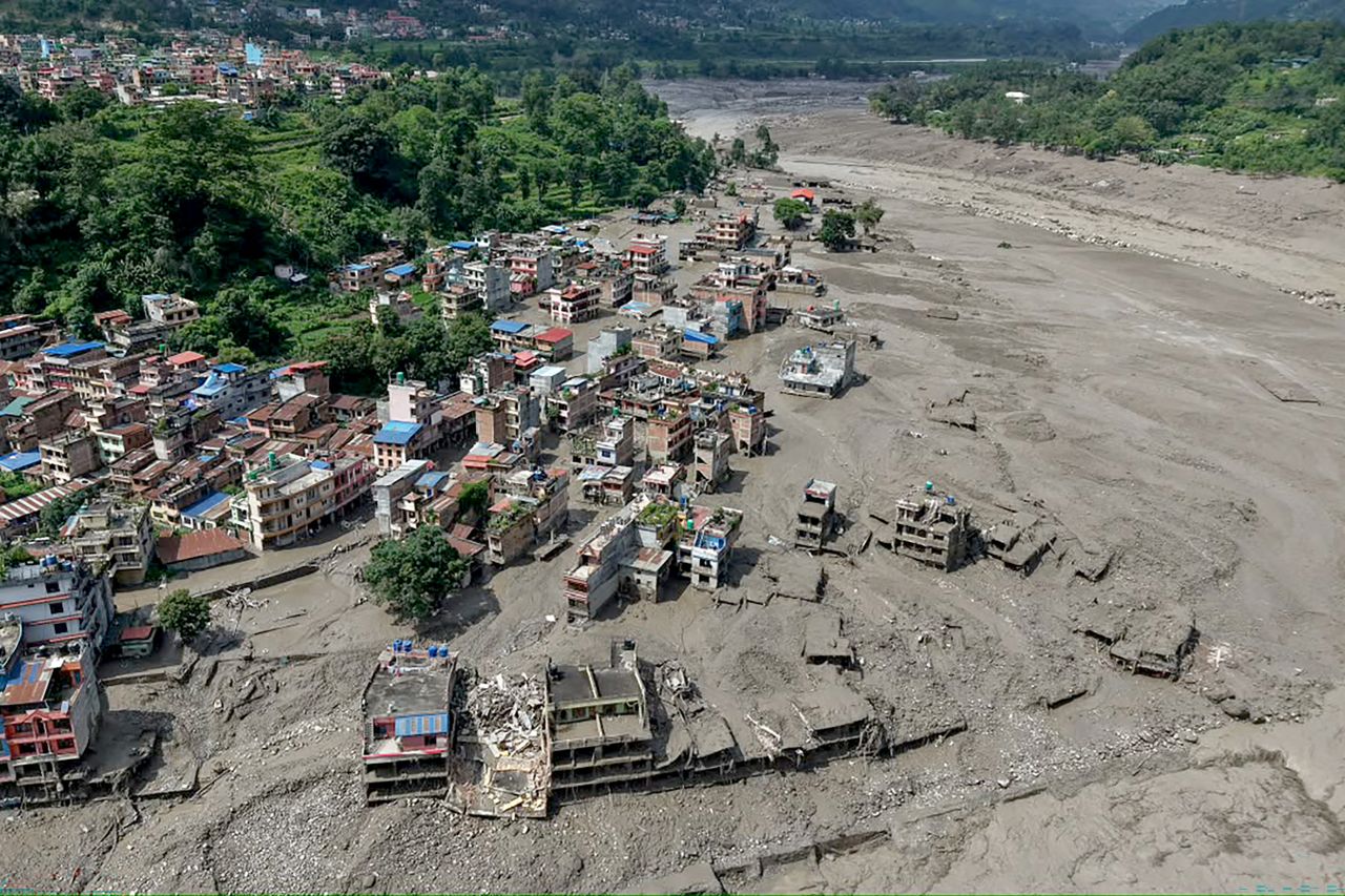 Houses lie partially submerged in muddy water along a riverside after flash floods at Trishuli Bazar in Nepal's Nuwakot district on August 26.