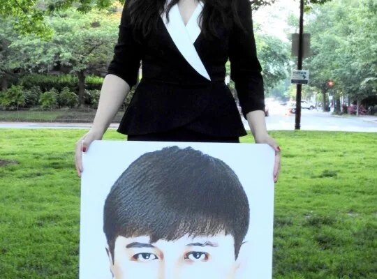 Rayhan Asat holds a picture of her brother, Ekpar, who went missing in 2016 after returning to Xinjiang from a trip to Washington, D.C., following participation in the State Department's International Visitor Leadership Program.