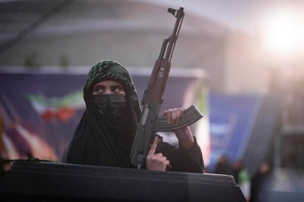 A pro-government supporter in Tehran holds an AK-45 rifle during a military parade.