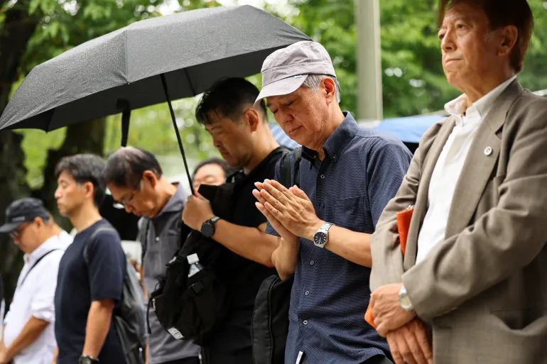 A man gestures as people pay a silent tribute to the war dead at Yasukuni Shrine on the 81st anniversary of Japan's surrender in World War Two, in Tokyo, Japan, August 15, 2026. REUTERS/Issei Kato