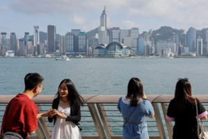 Tourists take photo of the skyline of buildings at Tsim Sha Tsui, in Hong Kong, China, May 2, 2023. Photo by Reuters