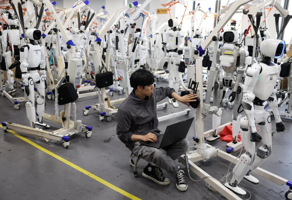An engineer works near Tiangong Omni humanoid robots in the research and testing area of the Beijing Humanoid Robot Innovation Center, also known as X-Humanoid, in Beijing, China, September 4, 2026. (Reuters)
