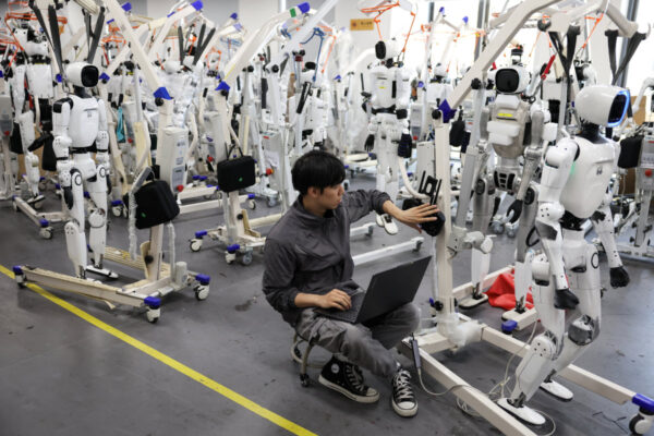 An engineer works near Tiangong Omni humanoid robots in the research and testing area of the Beijing Humanoid Robot Innovation Center, also known as X-Humanoid, in Beijing, China, September 4, 2026. (Reuters)