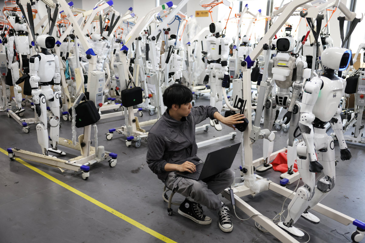 An engineer works near Tiangong Omni humanoid robots in the research and testing area of the Beijing Humanoid Robot Innovation Center, also known as X-Humanoid, in Beijing, China, September 4, 2026. (Reuters)