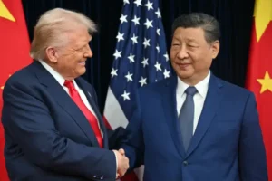 US President Donald Trump (L) and China's President Xi Jinping shake hands as they arrive for talks at the Gimhae Air Base, located next to the Gimhae International Airport in Busan on October 30, 2025. Donald Trump and Chinese leader Xi Jinping will seek a truce in their bruising trade war on October 30, with the US president predicting a "great meeting" but Beijing being more circumspect. (Photo by ANDREW CABALLERO-REYNOLDS / AFP)