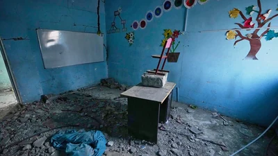 Colourful tree and flower decorations remain on the walls of a rubble-strewn classroom at Shajareh Tayyebeh school, damaged in a U.S. airstrike on February 28, in Minab, southern Iran. (AP Photo)