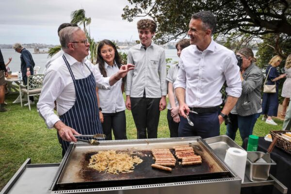 Australian Prime Minister Anthony Albanese (left) talks to schoolchildren and the Premier of South Australia Peter Malinauskas (right), as he cooks sausages on a barbecue during an official function to mark the start of Australia’s social media reform at Kirribilli House in Sydney on December 10, 2025. Photo: AFP
