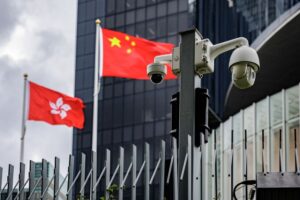 Surveillance camera seen in front of the Hong Kong National's flag and China flag in Hong Kong.