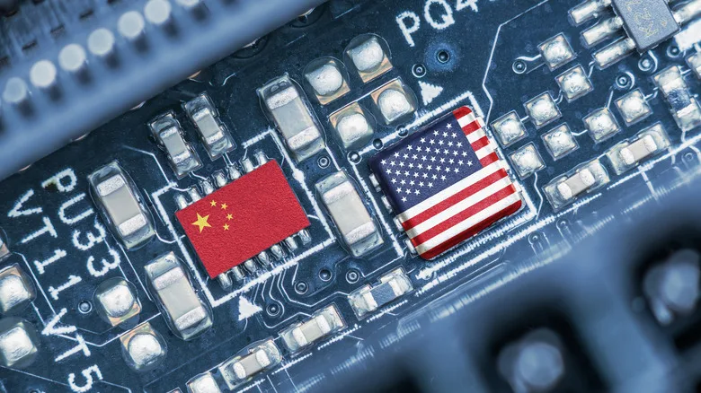 Flag of USA and China on a processor, CPU or GPU microchip on a motherboard. US companies have become the latest collateral damage in US - China tech war. US limits, restricts AI chips sales to China.