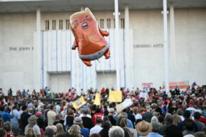 TOPSHOT - A balloon depicting US President Donald Trump is seen flying as people gather during a rally in support of the Kennedy Center in Washington, DC, on September 18, 2026. (Photo by Kent NISHIMURA / AFP via Getty Images)