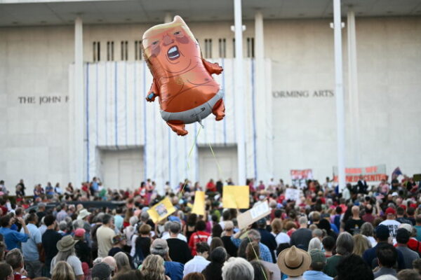 TOPSHOT - A balloon depicting US President Donald Trump is seen flying as people gather during a rally in support of the Kennedy Center in Washington, DC, on September 18, 2026. (Photo by Kent NISHIMURA / AFP via Getty Images)