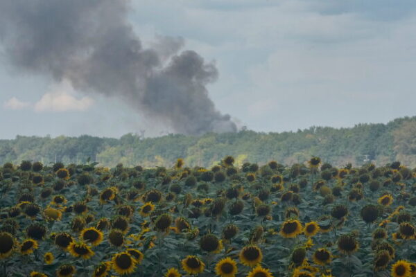 Smoke rises above warehouse stores behind a sunflower field following a Russian air attack in Kyiv, Ukraine, Thursday, Aug. 27, 2026. (AP Photo/Efrem Lukatsky)