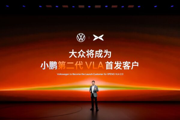 XPeng CEO He Xiaopeng on stage announcing Volkswagen as the launch customer for XPeng's VLA 2.0 driving system.
