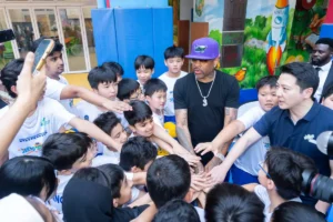 Allen Iverson and Mr. William Fong, Chairperson of IHKSports, interact with primary school students .